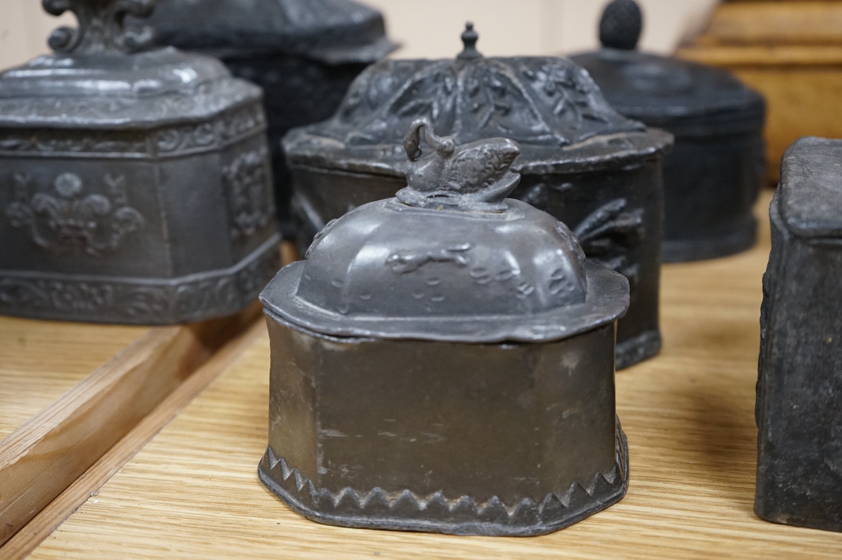 A collection of eleven early 19th century lead tobacco boxes to include an octagonal example with remains of red paint, largest 13cm wide